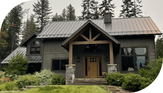 Curbside view of a forest green home with a new metal roof in Flathead Valley courtesy of Titan Roofing