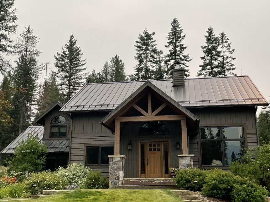 Curbside view of a forest green home with a new metal roof in Flathead Valley courtesy of Titan Roofing